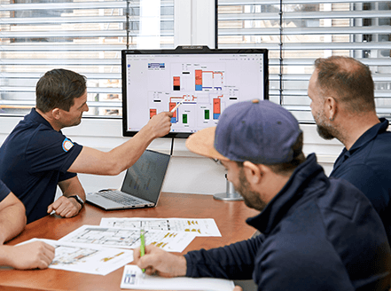 Handwerker zeigt auf einen Computer